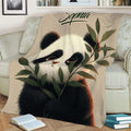 Close lifestyle view of a panda throw blanket with leafy bamboo artwork on a sofa