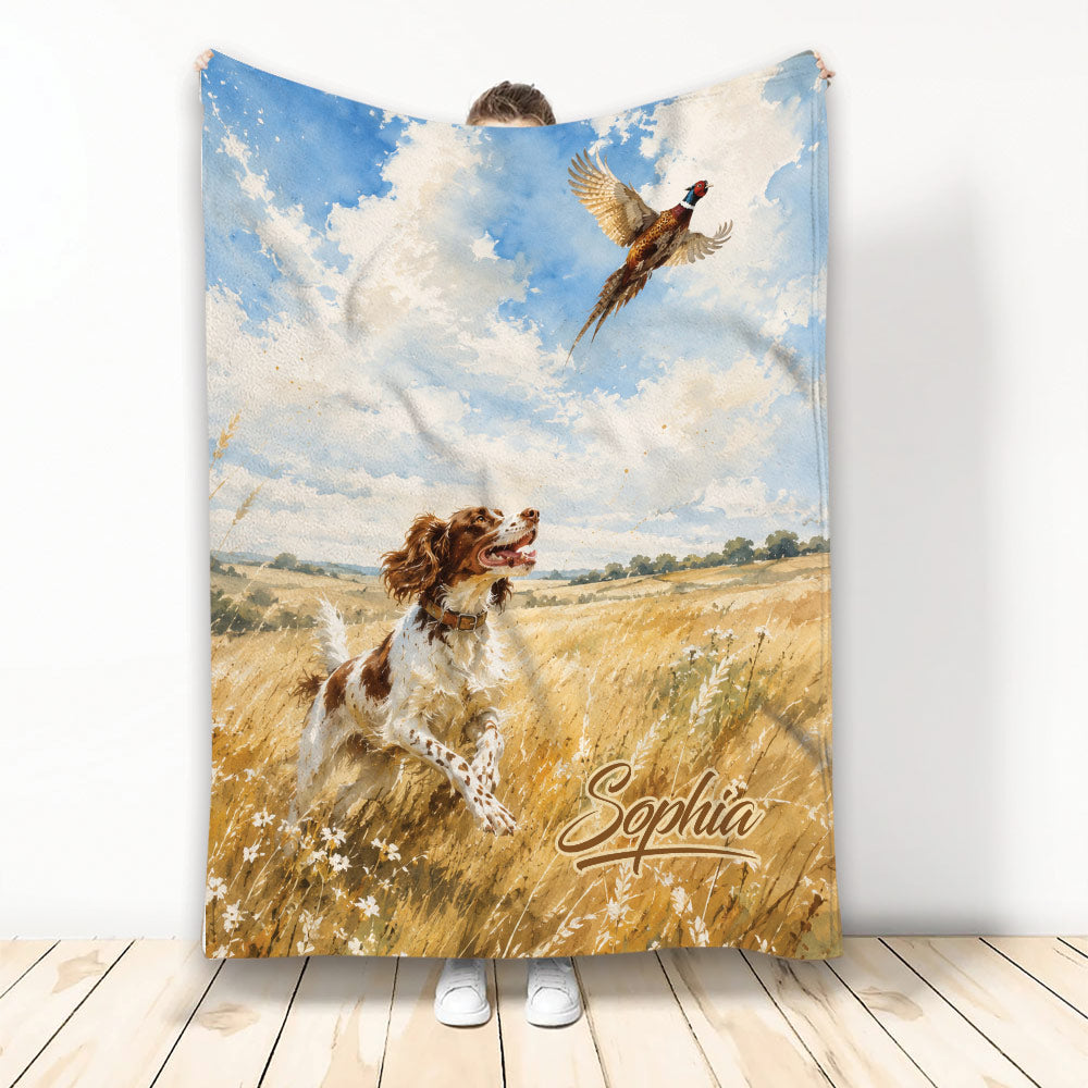 Brittany Spaniel running through a golden field beneath blue skies with a flying game bird