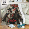 Knights Templar throw blanket displayed on a sofa, featuring an armored knight on horseback in red and black artwork