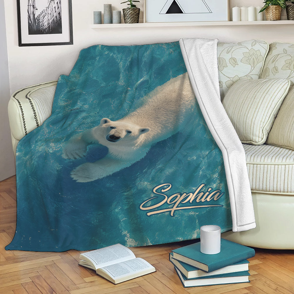 Polar bear throw blanket displayed across a living room sofa with blue aquatic artwork