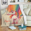 Rainbow unicorn throw blanket draped across a sofa in a cozy living room