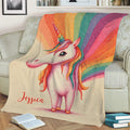 Bright unicorn blanket displayed on a sofa with whimsical rainbow artwork