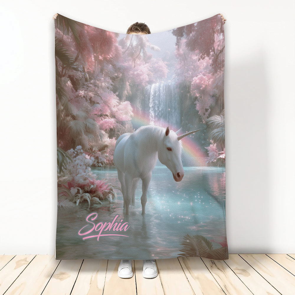 Unicorn throw blanket featuring a white unicorn in a pastel enchanted forest with waterfall and rainbow