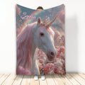 Unicorn throw blanket featuring a white unicorn with pink mane, jeweled horn, rainbow, butterflies, and flowers