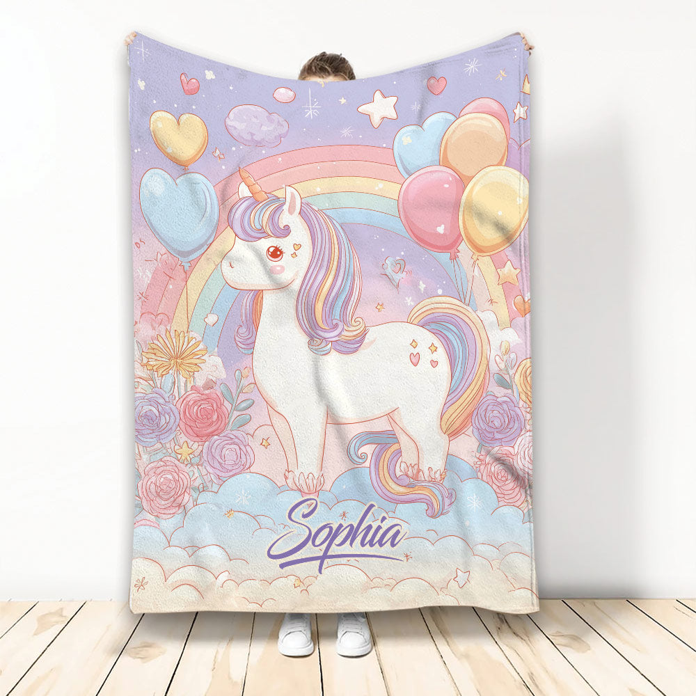 Pastel unicorn throw blanket displayed upright with rainbows, balloons, flowers, stars, and heart details
