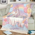 Colorful unicorn throw blanket spread across a sofa with pastel rainbows, roses, balloons, and stars