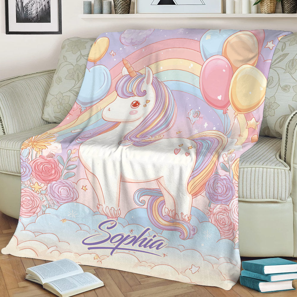 Colorful unicorn throw blanket spread across a sofa with pastel rainbows, roses, balloons, and stars