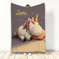 Unicorn throw blanket displayed with a dreamy sleeping unicorn, stars, and warm neutral colors