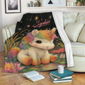 Colorful unicorn throw blanket draped over a living room sofa with stars, flowers, and mushrooms