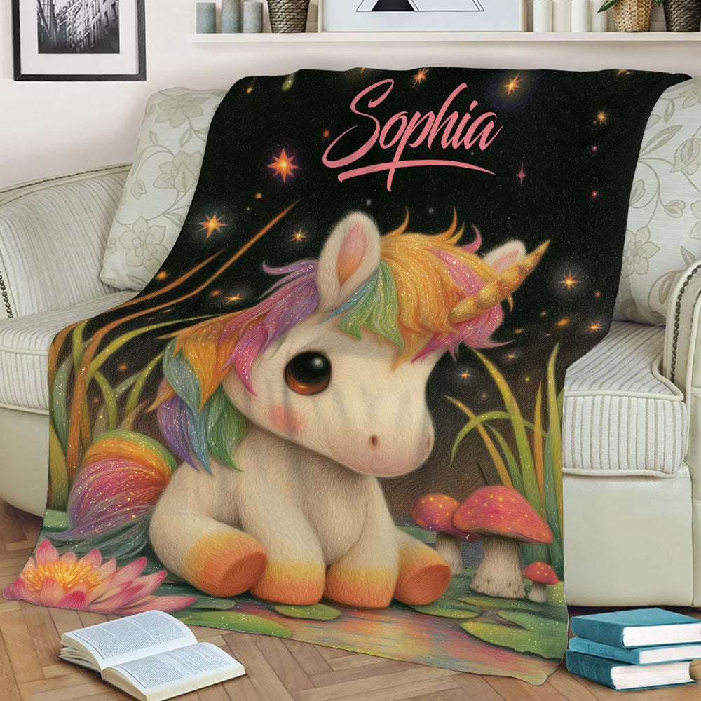 Whimsical unicorn blanket displayed on a sofa with rainbow mane, glowing stars, flowers, and mushrooms