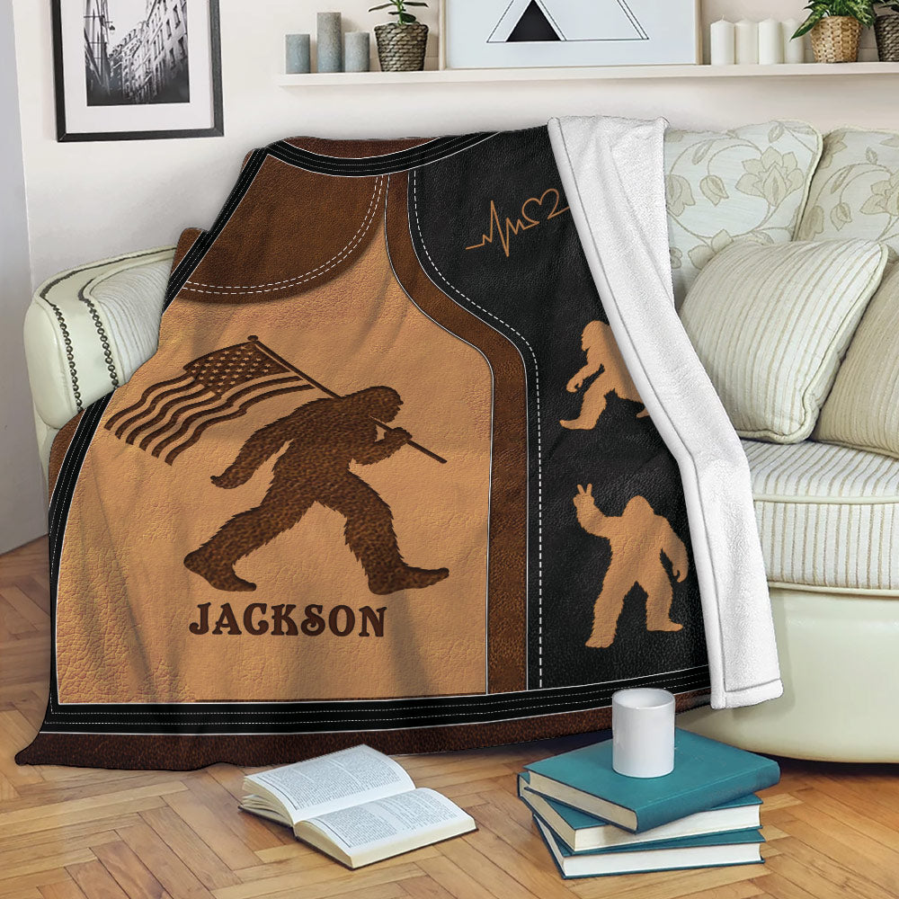 Bigfoot throw blanket with patriotic artwork draped over a living room sofa