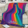 Colorful Bigfoot throw blanket displayed across a sofa with rainbow beams and woodland artwork