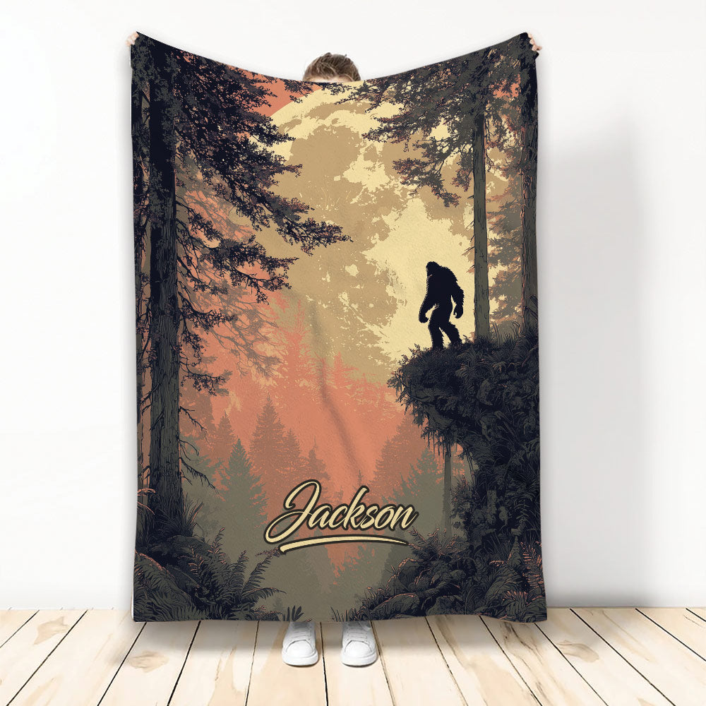 Bigfoot throw blanket featuring a forest scene, silhouetted Sasquatch, and warm rustic colors