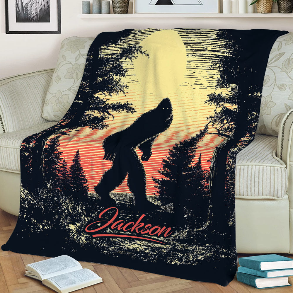 Bigfoot throw blanket draped over a sofa, showing a Sasquatch walking through a forest