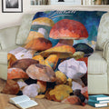 Close view of a mushroom throw blanket styled on a sofa with painterly fungi artwork