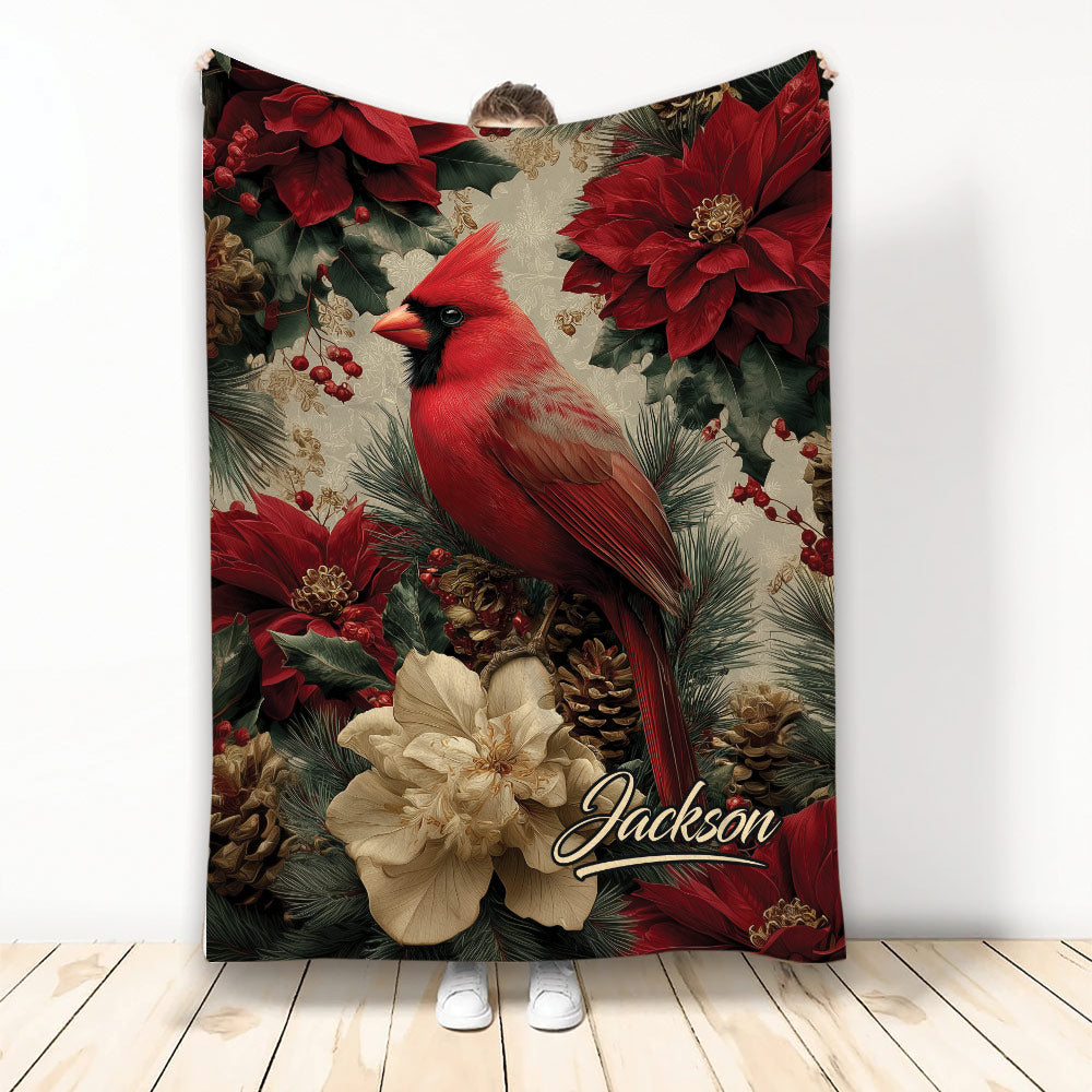 Red cardinal blanket surrounded by poinsettias, pine branches, berries, and festive winter florals