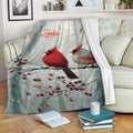 Cardinal blanket draped over a sofa with red bird artwork, snowy branches, and berry accents