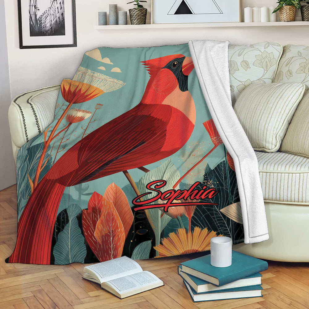 Cardinal throw blanket draped over a sofa with colorful botanical artwork and cozy reading nook decor