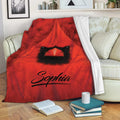 Red cardinal blanket draped across a sofa with bold bird artwork and cozy reading decor