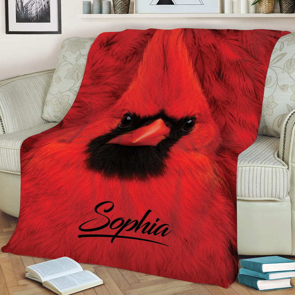 Close-up red cardinal throw blanket styled on a sofa with dramatic bird artwork