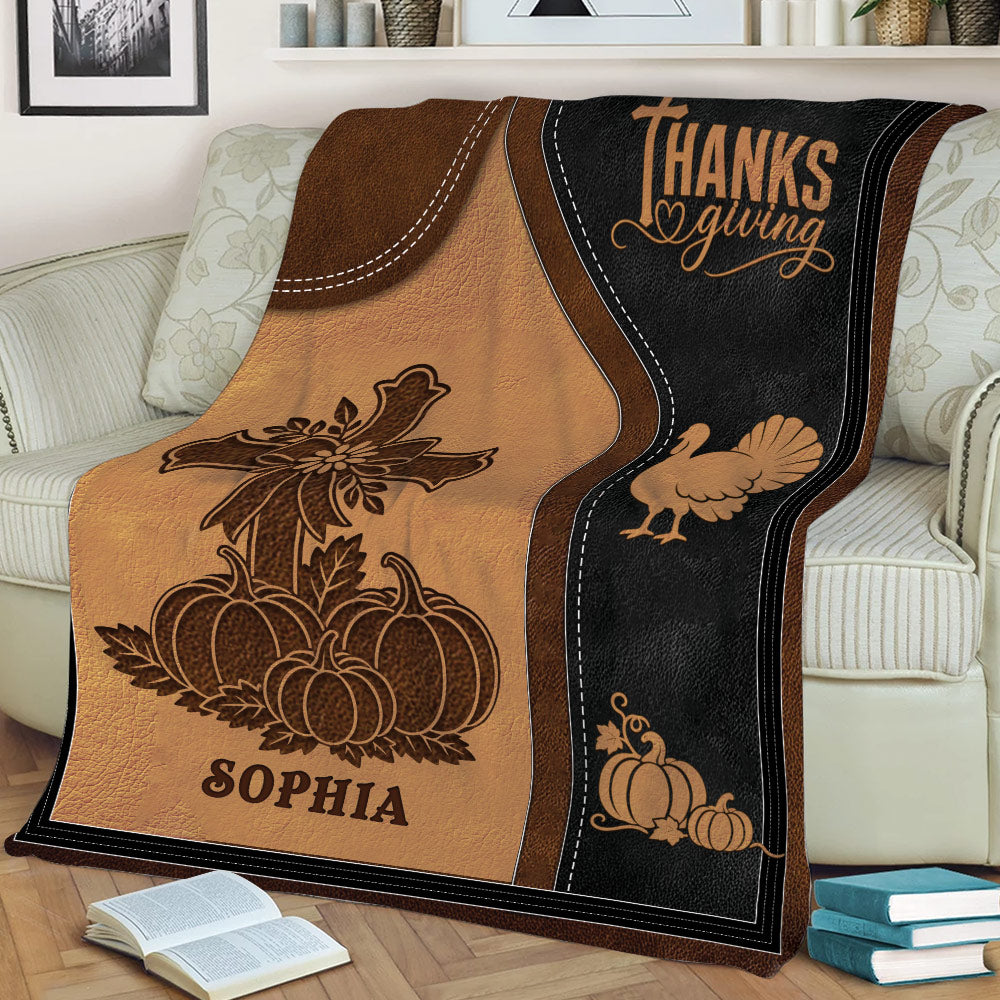 Close view of Thanksgiving blanket featuring pumpkins, turkey, cross artwork, and warm fall colors