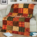 Autumn Thanksgiving throw blanket draped over a sofa with colorful plaid patchwork design