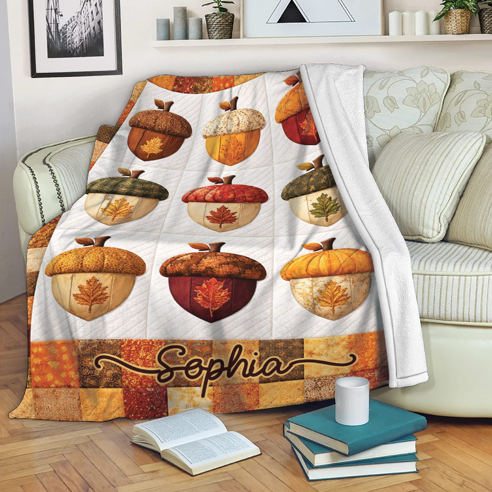 Thanksgiving throw blanket displayed on a sofa with acorn artwork, autumn leaves, and rustic fall colors