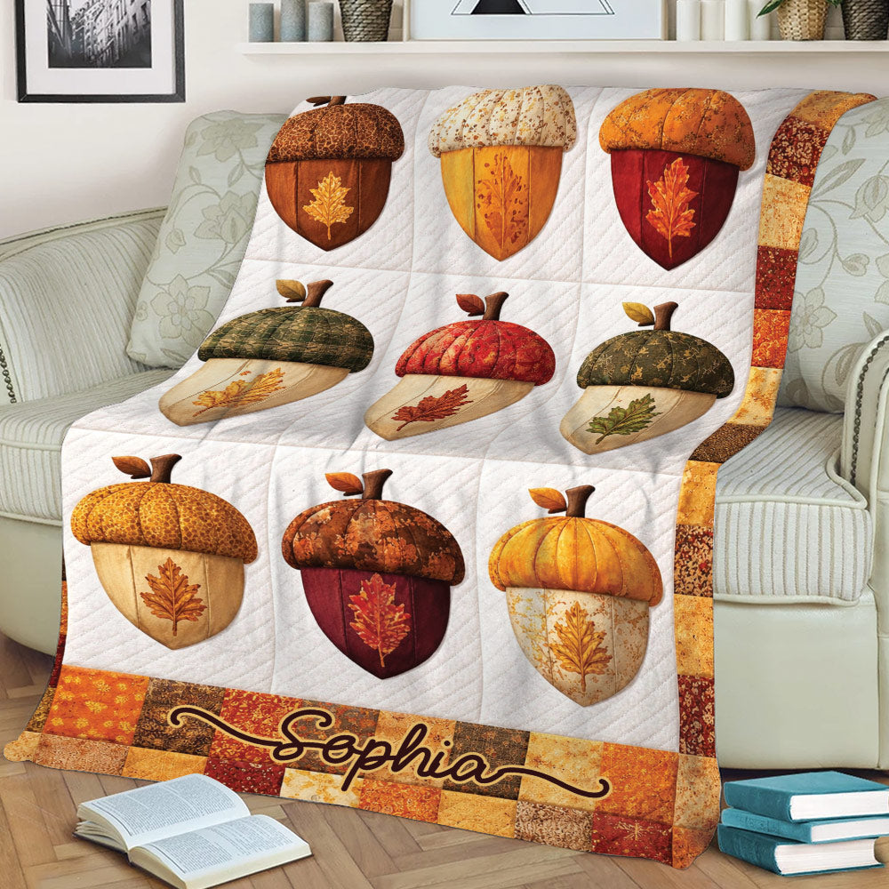 Close view of an autumn Thanksgiving blanket featuring colorful acorns, leaves, pumpkins, and patchwork details