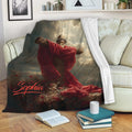 Christian cross blanket displayed on a sofa with reverent Jesus artwork and rich red and gold tones
