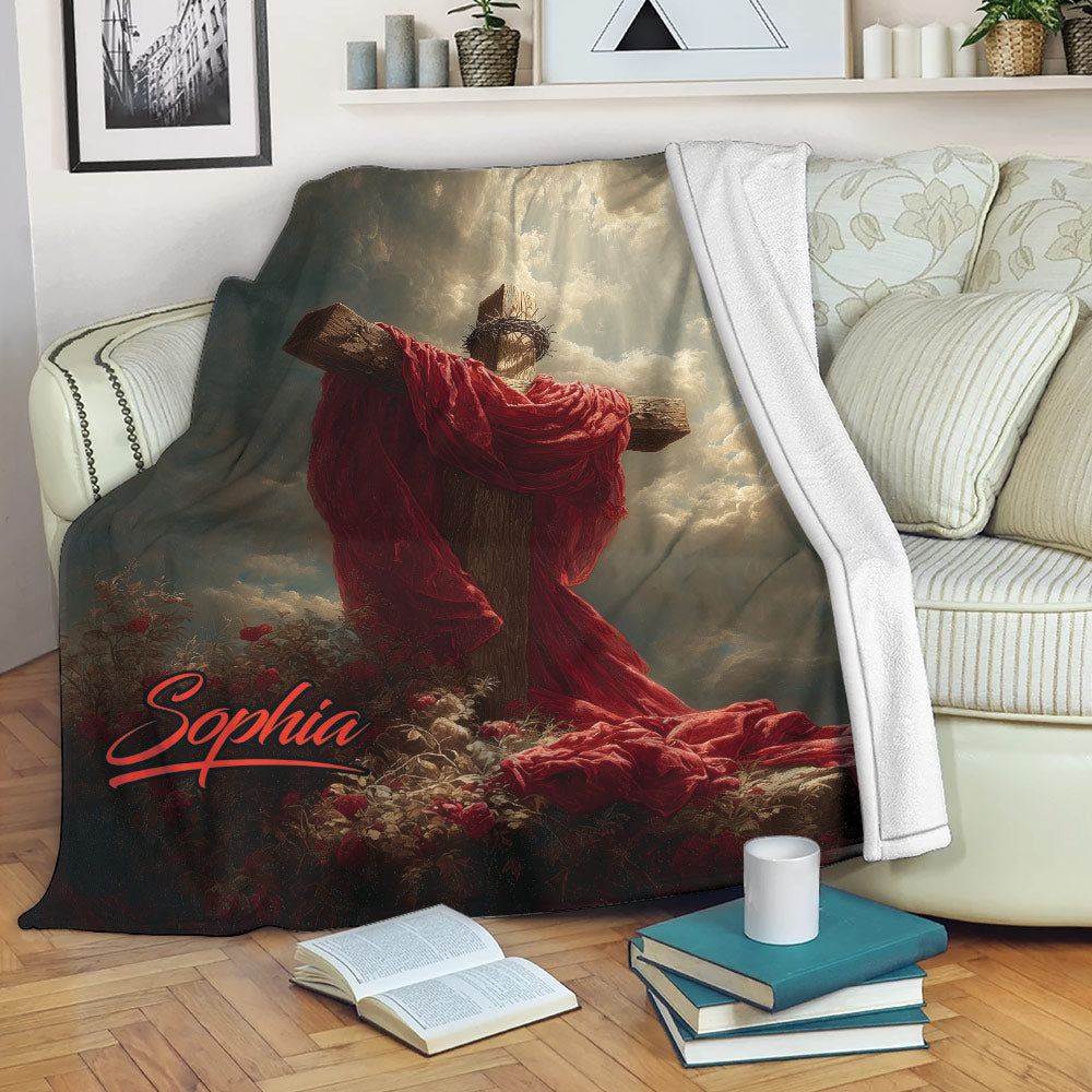 Christian cross blanket displayed on a sofa with reverent Jesus artwork and rich red and gold tones