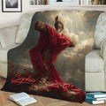 Close view of a Christian throw blanket with crucifix artwork, glowing clouds, and deep crimson fabric