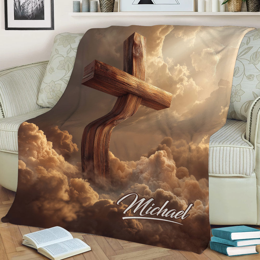 Faith-inspired cross throw blanket displayed on a sofa with glowing clouds