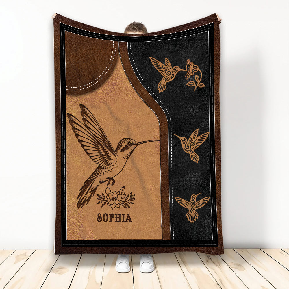 Hummingbird throw blanket with brown and black stitched-style artwork and floral accents