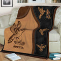 Close view of a hummingbird throw blanket with floral details in a cozy living room