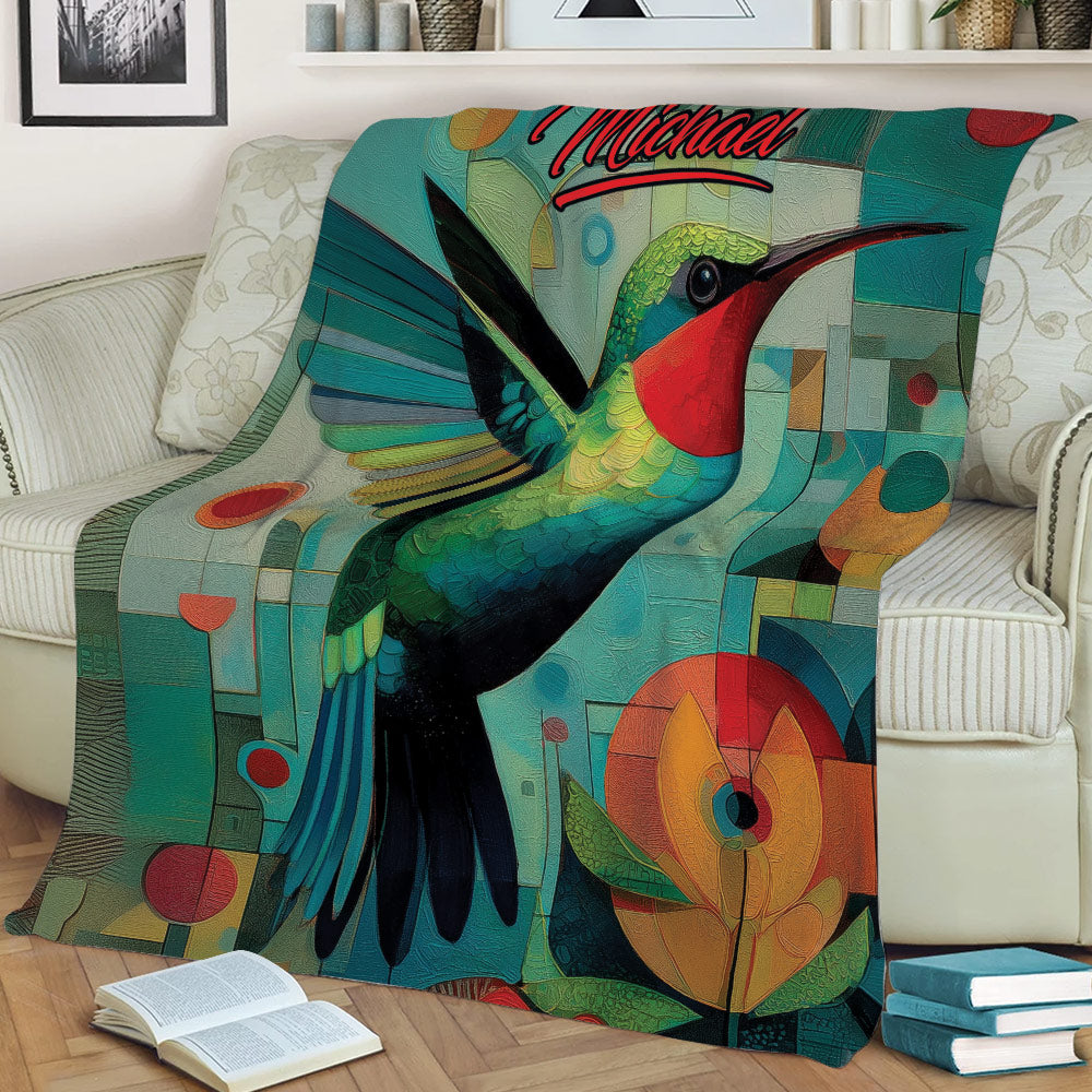 Close view of a hummingbird throw blanket with vibrant geometric and floral artwork on a sofa