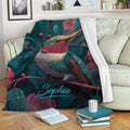 Hummingbird throw blanket draped over a sofa with vibrant floral and foliage artwork