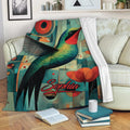 Colorful hummingbird throw blanket displayed on a sofa with geometric art and floral accents