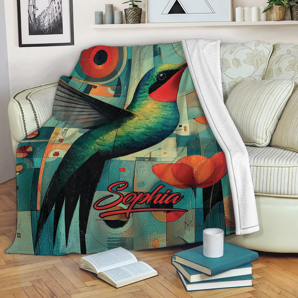 Colorful hummingbird throw blanket displayed on a sofa with geometric art and floral accents