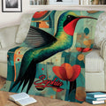 Jewel-toned hummingbird blanket draped across a sofa with abstract geometric artwork