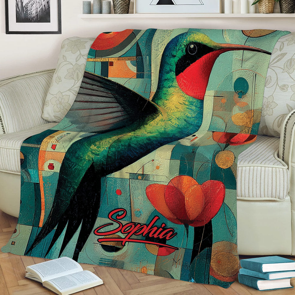 Jewel-toned hummingbird blanket draped across a sofa with abstract geometric artwork