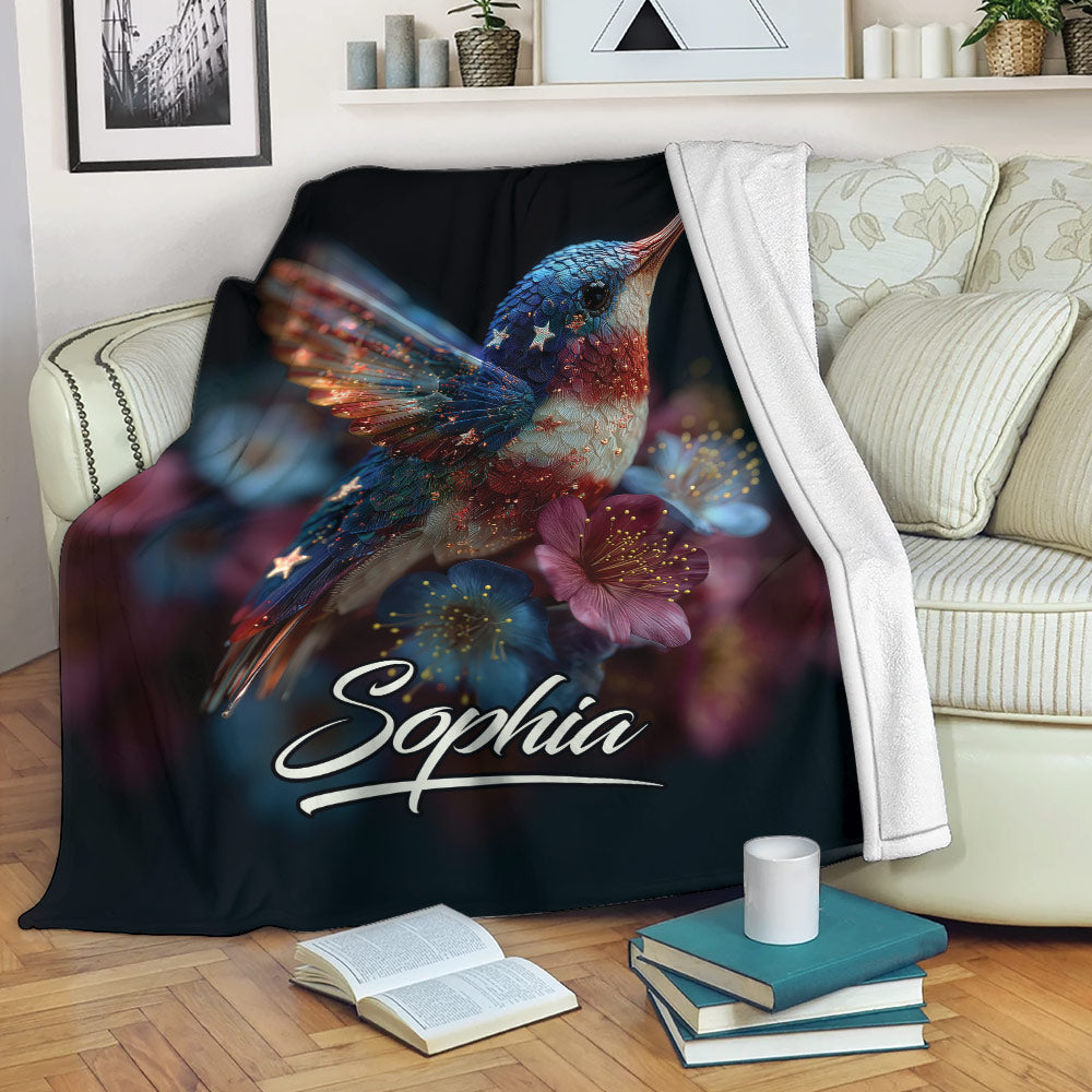 Hummingbird throw blanket displayed on a sofa with colorful floral artwork