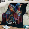 Colorful hummingbird and flower throw blanket styled across a living room sofa