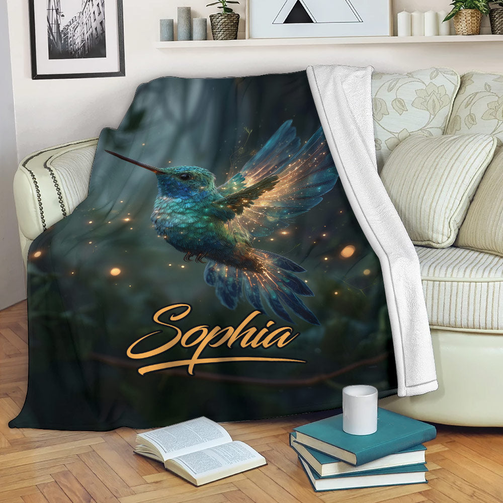 Hummingbird blanket draped over a sofa with luminous blue bird artwork