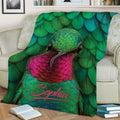 Close view of vibrant hummingbird artwork on a blanket styled across a sofa