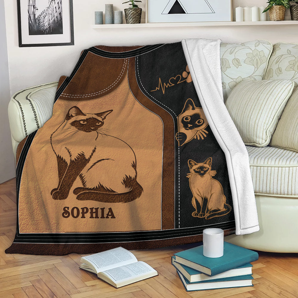 Siamese cat blanket draped over a sofa with vintage cat illustrations and cozy living room styling