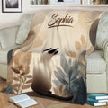Botanical Siamese cat blanket displayed across a sofa with books nearby