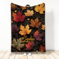 Autumn leaves throw blanket with colorful fall foliage on a dramatic black swirling background