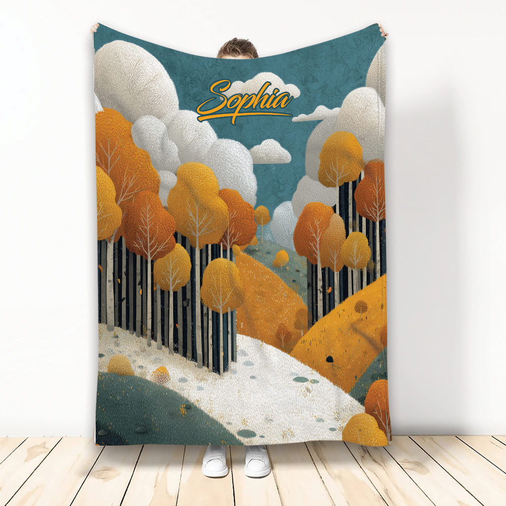 Autumn throw blanket with a custom design featuring orange trees, rolling hills, clouds, and a woodland path