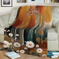 Close view of an autumn woodland throw blanket with colorful trees and white flowers