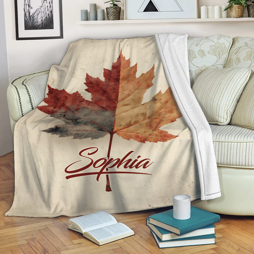 Custom autumn leaves throw blanket displayed on a cozy sofa with books and home decor